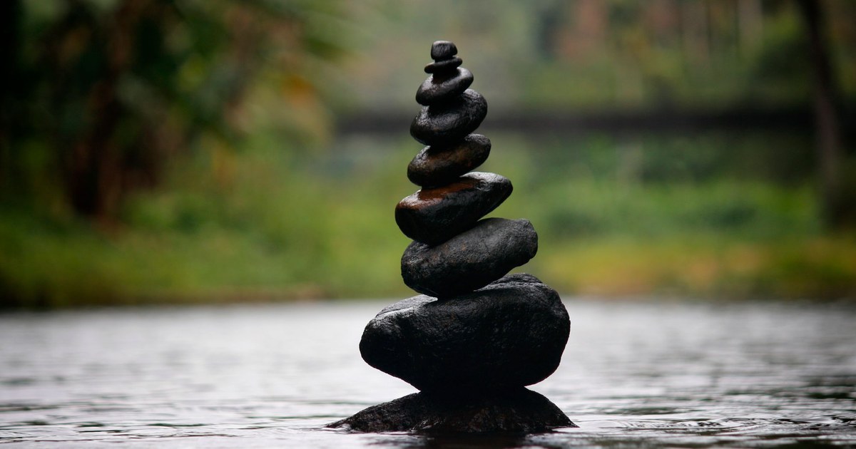A stack of balanced stones rising from calm water