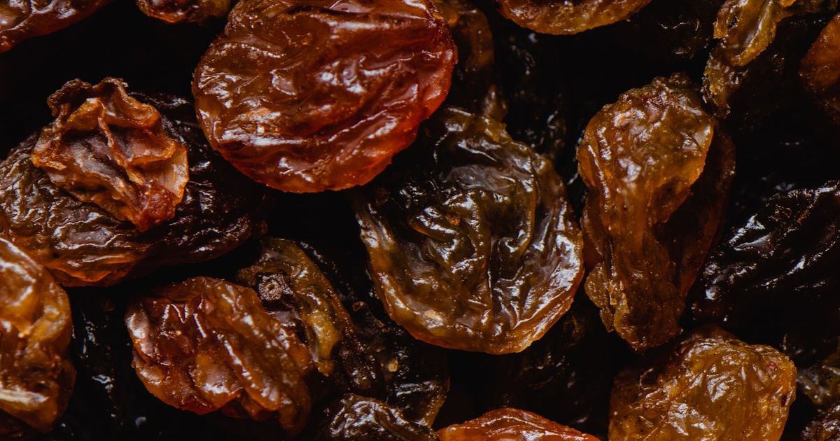 A warm close-up of amber and reddish-brown raisins