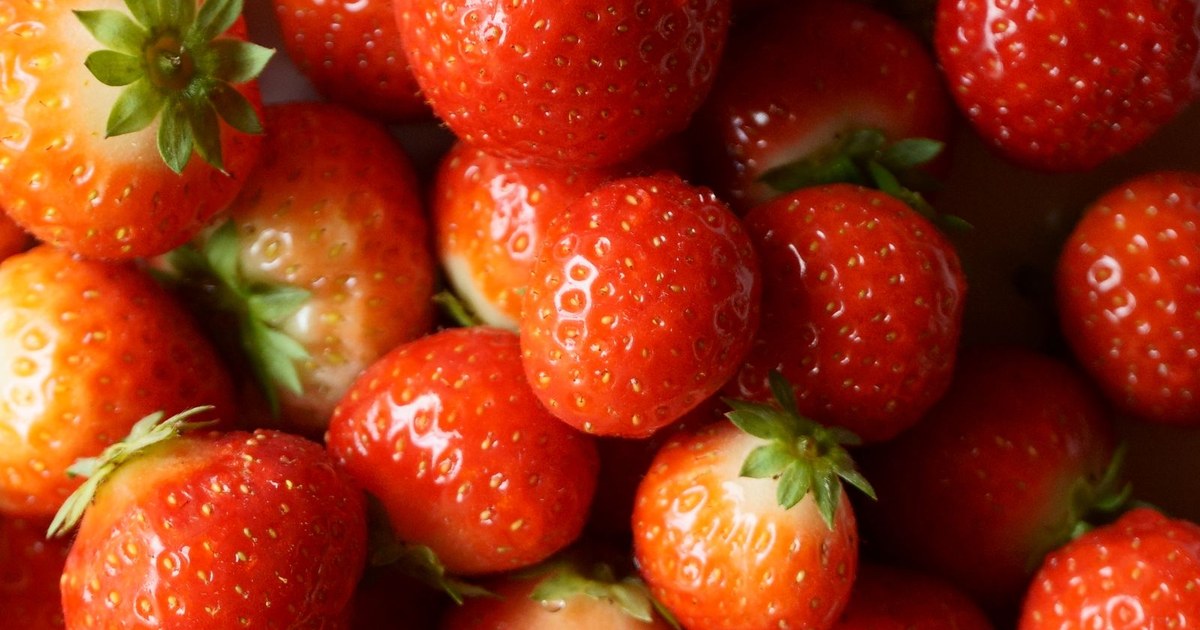 A close-up pile of fresh ripe red strawberries
