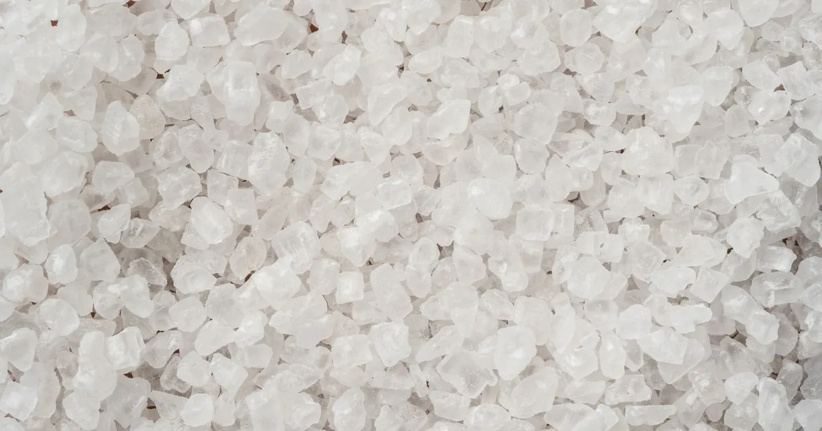A close-up, full-frame view of coarse white sea salt crystals filling the entire frame