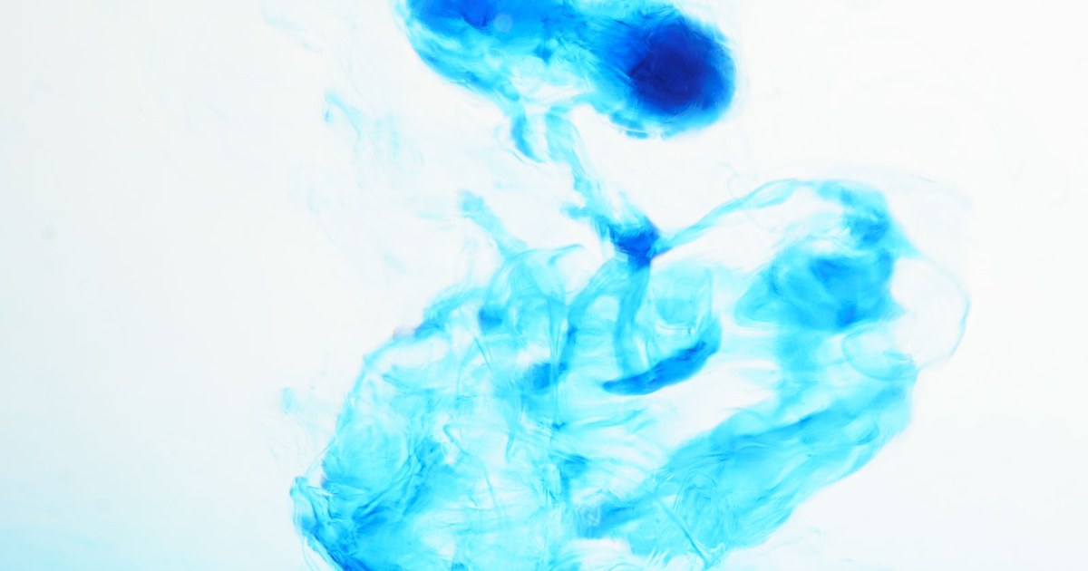 A cloud of deep blue dye dispersing in clear water
