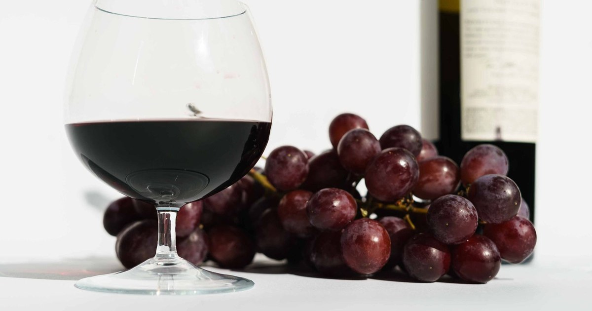 Red grapes beside a glass of red wine
