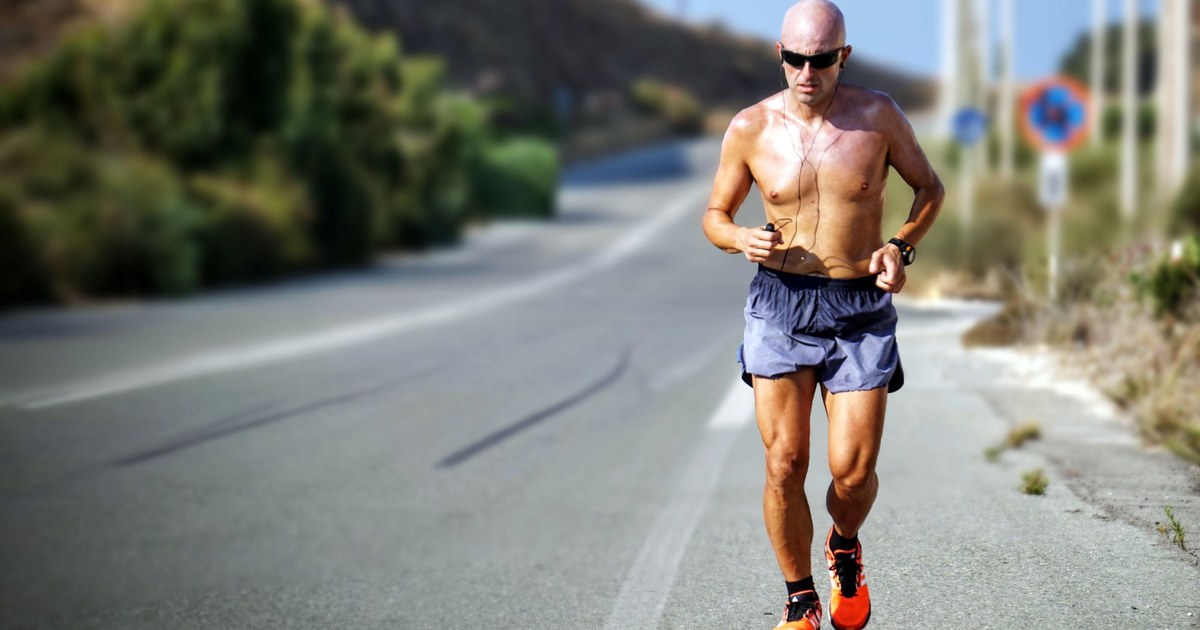 A man running on a sunlit open road